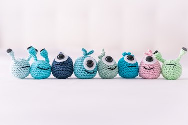 A lot of crocheted funny little monsters on a white surface (handmade)