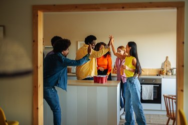 Friends high five at house party.