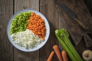 Chopped vegetables on a plate, plus whole carrots, celery, and onion