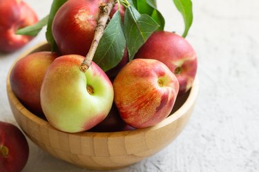 Ripe fresh nectarines on white stone background, healthy organic food, summer fruit