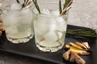 Two glasses with a beverage, homemade ice cubes and ginger