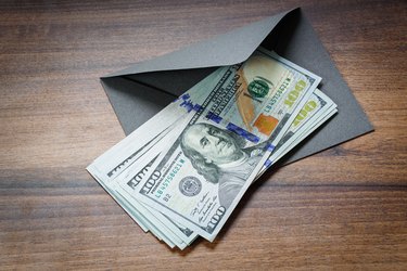 American dollars and envelope on table