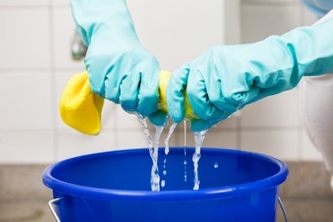 Squeezing cloth over bucket