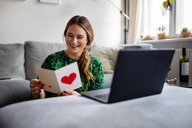 Woman reading a greeting card during a video call
