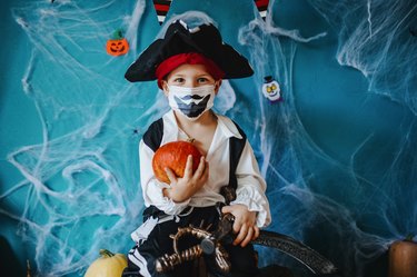 Little boy wearing Halloween costume and protective face mask during Covid-19 pandemic