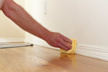 Dusting a baseboard