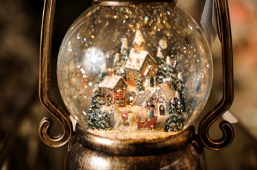 close-up view on small town with snowy houses inside transparent round Christmas ball