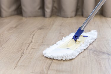 Modern white mop cleaning a wooden floor