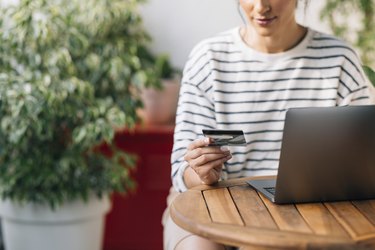 Anonymous Woman Dressed in a Striped Sweater, Shopping Online Using Her Credit Card
