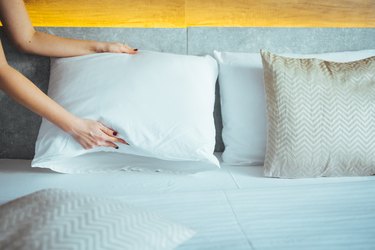Placing pillow on bed