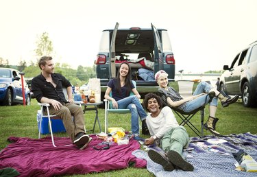 Happy friends enjoying at campsite against clear sky