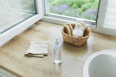 Straw basket with natural eco friendly cleaning products and brushes placed for cleaning the window ethically.