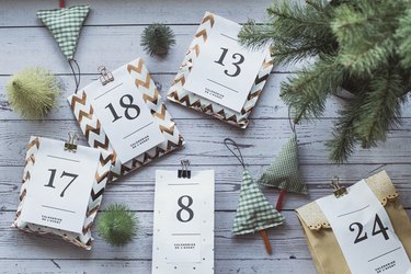 Overhead view of gifts for an advent calendar next to Christmas decorations