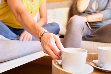 Unrecognizable lesbian female couple with LGBT rainbow bracelet