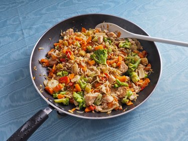 Chicken and Asian vegetable stir fry in a nonstick pan with white spatula
