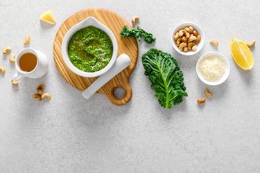 Pesto kale with ingredient for cooking on home kitchen table
