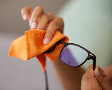 Shot of an unrecognizable person cleaning glasses at home