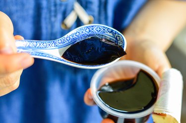 Woman spoons up black Guiling Gao, a jelly-like Chinese medicine also a dessert