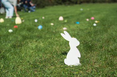 Easter white bunny and eggs in the grass. Easter egg hunting tradition