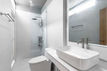 White Modern and Wood Bathroom with Shower Cabin Glass and Big mirror in Apartment