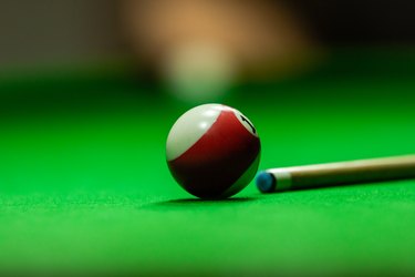 Pool table with stick and ball in a club house
