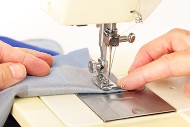 Close up of a piece of fabric and hands working on a sewing machine