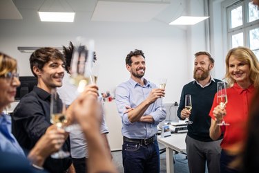 Happy business professionals with champagne flutes in office