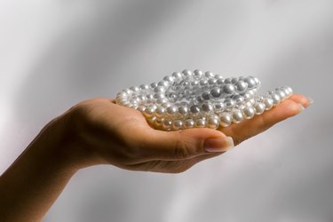 Woman's hand holding costume pearls