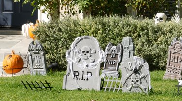 Scary festival decorations of a house, Happy Halloween holiday. Classic garden with Pumpkin, Bones and Skeleton. Traditional party decor. American culture