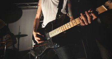 Hard Rock guitarist playing guitar in a live show with stage lights