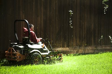 Working class. Man mows lawn using industrial lawn mower.