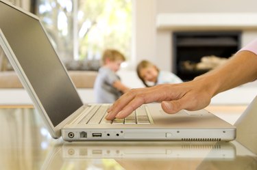 Hands of woman typing on laptop computer