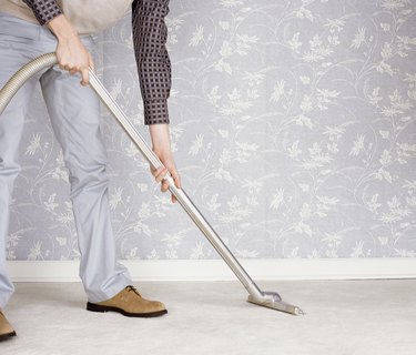 Low Section of a Man Using a Vacuum Cleaner