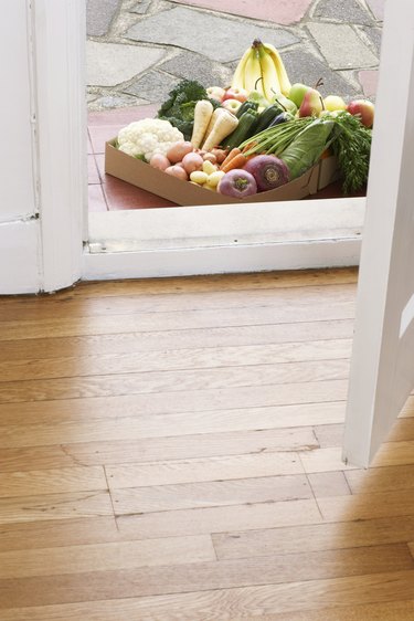 Cardboard box of assorted vegetables at house doors