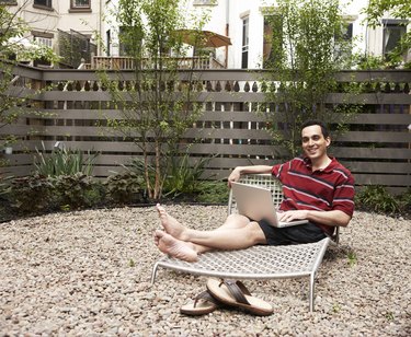 Relaxing on lounge chairs in urban backyard