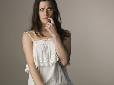 Pensive woman biting finger