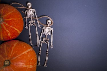 Human skeletons on a rope on a dark background. The day of the Dead.