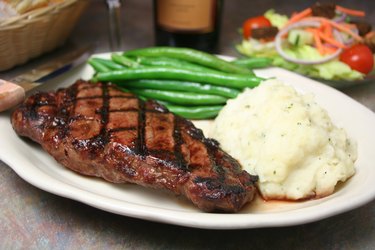 Steak dinner with mashed potatoes and steamed green beans