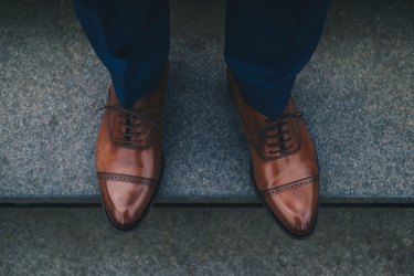 Low Section Of Man Wearing Shoes While Standing On Steps