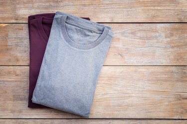 Top view of color T-Shirt on grey wood plank