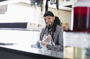 Worker in commercial kitchen putting on gloves