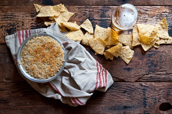A freshly baked batch of jalapeno popper beer cheese dip served with tortillas.