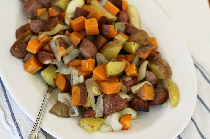 Chicken sausage with sweet potatoes, onions and apples ready to serve