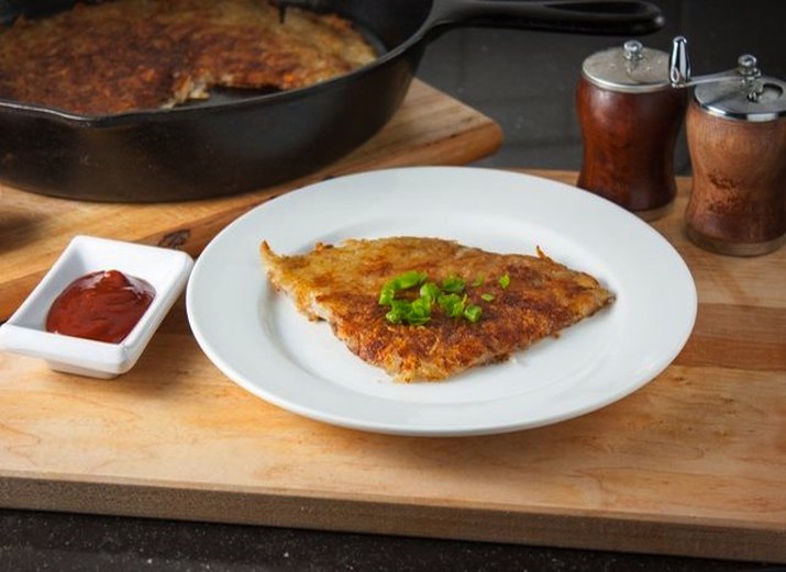Plate of hash browns with a side of ketchup.