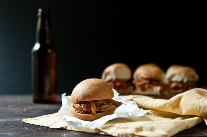 Multiple chipotle beer chicken sliders served with a bottle of brew.
