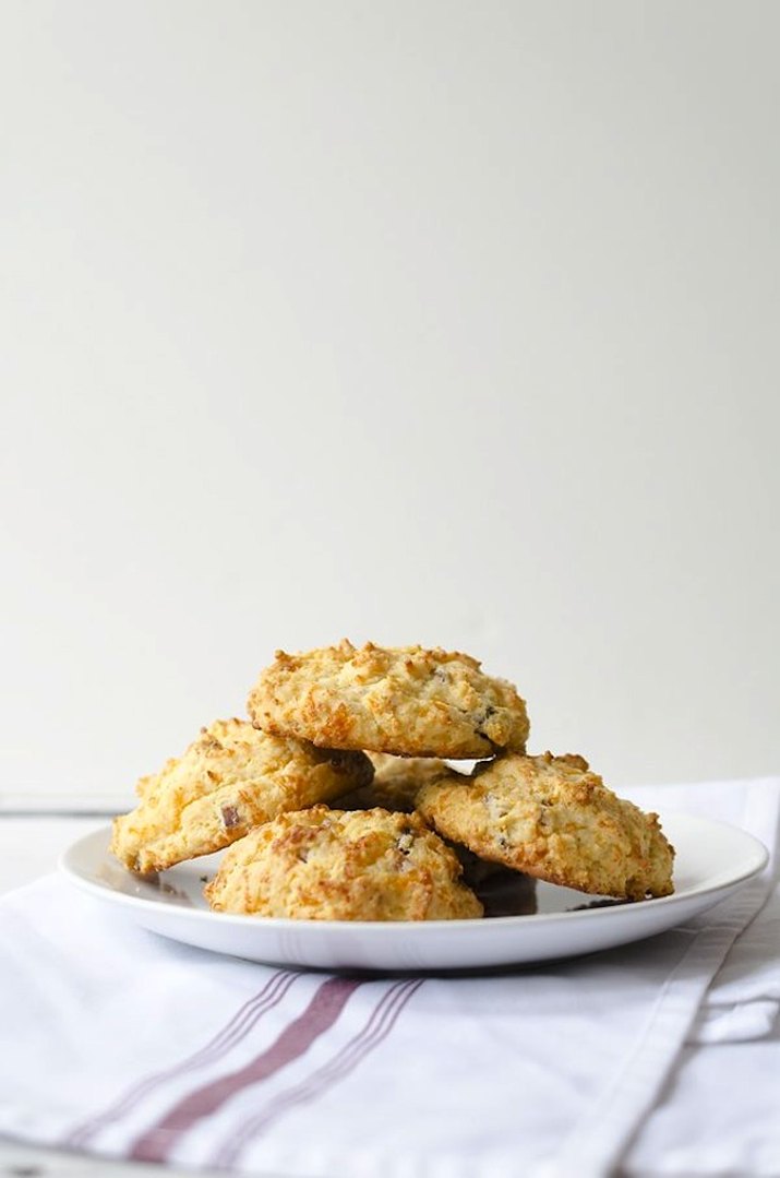 Bacon cheddar biscuits piled on plate.