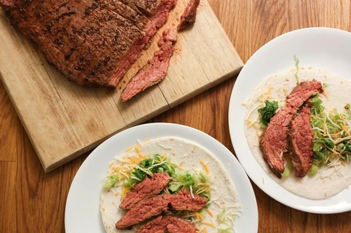 Plate with skirt steak tacos with lettuce and cheese.