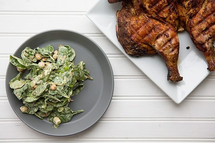 A plate of tandoori masala spiced chicken with a side of creamy chickpea and spinach salad.